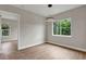 Bright dining room with modern light fixture, wood floors, and large windows showcasing the greenery outside at 18399 Hillsborough Blvd, Port Charlotte, FL 33954