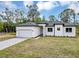 Exterior featuring modern design, manicured lawn, paved driveway and attached garage at 18399 Hillsborough Blvd, Port Charlotte, FL 33954