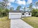 Front exterior view of modern home featuring a clean design, attached garage, and paved driveway at 18399 Hillsborough Blvd, Port Charlotte, FL 33954
