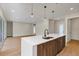 Kitchen island with stainless steel dishwasher and sink, wood-style cabinets, pendant lights at 18399 Hillsborough Blvd, Port Charlotte, FL 33954