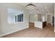 Spacious open-concept living area with wood floors, modern lighting, and an inviting kitchen in the background at 18399 Hillsborough Blvd, Port Charlotte, FL 33954