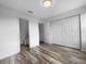 Neutral bedroom featuring wood floors, double door closet, and access to a private bathroom at 8869 White Sage Loop, Lakewood Ranch, FL 34202