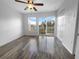 Bedroom featuring wood floors, natural light, and a sliding glass door to a private balcony at 8869 White Sage Loop, Lakewood Ranch, FL 34202