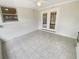 Neutral sunroom with tile flooring, white walls, a window and double doors leading outside at 5531 9Th N Ave, St Petersburg, FL 33710