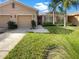 Charming home featuring a lush lawn, palm trees, and a two-car garage at 11535 52Nd E Ct, Parrish, FL 34219