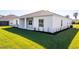 The backyard offers a covered patio and lush landscaping with newly planted shrubbery along the home's perimeter at 25372 Alicante Dr, Punta Gorda, FL 33955