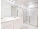 Elegant bathroom with double sinks, marble tiling, and a glass-enclosed shower at 25372 Alicante Dr, Punta Gorda, FL 33955