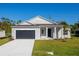 Charming single-story home with a well-manicured lawn, a dark gray garage door, and neutral color palette at 25372 Alicante Dr, Punta Gorda, FL 33955