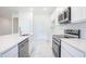 Modern kitchen with white cabinets, stainless steel appliances, and tile backsplash, complemented by tile floors at 25372 Alicante Dr, Punta Gorda, FL 33955