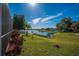 Scenic backyard overlooking a tranquil lake, with vibrant landscaping and lush green grass at 31028 Baclan Dr, Wesley Chapel, FL 33545