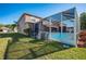 Expansive screened-in patio for outdoor entertaining, complemented by a well-maintained lawn at 31028 Baclan Dr, Wesley Chapel, FL 33545