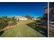 Expansive backyard featuring lush lawn and well maintained landscaping under a clear blue sky at 31028 Baclan Dr, Wesley Chapel, FL 33545