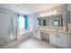 Bathroom featuring dual sinks, a shower, and a bathtub with blue curtains at 31028 Baclan Dr, Wesley Chapel, FL 33545