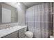 Bathroom featuring double sink vanity, shower with grey patterned curtain and tile mosaic backsplash at 31028 Baclan Dr, Wesley Chapel, FL 33545
