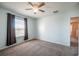 Serene bedroom with ceiling fan and large windows adorned with curtains, offering bright natural light at 31028 Baclan Dr, Wesley Chapel, FL 33545