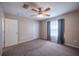 A spacious bedroom with neutral walls, carpet flooring, a ceiling fan, and closet space at 31028 Baclan Dr, Wesley Chapel, FL 33545