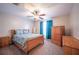 Cozy bedroom with wood furnishings, a ceiling fan and blue curtains, creating a serene retreat at 31028 Baclan Dr, Wesley Chapel, FL 33545