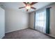 A well-lit bedroom with tan walls, carpet flooring, and a window with curtains at 31028 Baclan Dr, Wesley Chapel, FL 33545