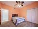 Bedroom with neutral carpet, ceiling fan, and closet space, creating a cozy atmosphere at 31028 Baclan Dr, Wesley Chapel, FL 33545
