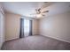 Inviting bedroom with neutral walls, carpet flooring, ceiling fan, and a window with curtains at 31028 Baclan Dr, Wesley Chapel, FL 33545