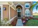 Inviting front entry featuring an arched doorway, decorative plants, and a well-maintained walkway at 31028 Baclan Dr, Wesley Chapel, FL 33545