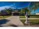 Charming two-story home featuring a well-manicured lawn, mature palms, and a wide driveway at 31028 Baclan Dr, Wesley Chapel, FL 33545