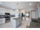 Bright kitchen features an island, white cabinets, stainless steel appliances, and granite countertops at 31028 Baclan Dr, Wesley Chapel, FL 33545