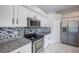 Close-up of the kitchen features stainless steel appliances, granite countertops, and white cabinetry at 31028 Baclan Dr, Wesley Chapel, FL 33545