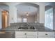 Kitchen pass-through features a stainless steel sink, granite countertops, and sleek white cabinetry at 31028 Baclan Dr, Wesley Chapel, FL 33545