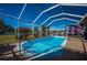 A refreshing screened-in pool under blue skies with a waterfront view and lush landscaping at 31028 Baclan Dr, Wesley Chapel, FL 33545
