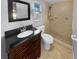 Modern bathroom features a dark wood vanity and a tiled shower with updated fixtures at 1848 Redcoat Ln, Clearwater, FL 33764