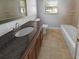 Bathroom featuring a vanity with dark countertop, white toilet and shower/bath combo at 1848 Redcoat Ln, Clearwater, FL 33764