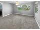 Bright bedroom with large window overlooking backyard and plush grey carpet at 1848 Redcoat Ln, Clearwater, FL 33764