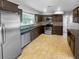Traditional kitchen featuring stainless steel appliances, brown cabinetry, and tile floors at 1848 Redcoat Ln, Clearwater, FL 33764