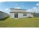 Backyard with a manicured lawn, sliding glass door and small tree at 31653 Wild Grape Ln, Brooksville, FL 34602