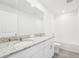 Well-lit bathroom features double sinks with granite countertop, and a tub with white tile surround at 31653 Wild Grape Ln, Brooksville, FL 34602