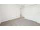 A well-lit bedroom with neutral carpeting and a closet at 31653 Wild Grape Ln, Brooksville, FL 34602