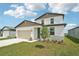 Charming two-story home featuring a 2-car garage, stone accents, and a well-manicured lawn at 31653 Wild Grape Ln, Brooksville, FL 34602