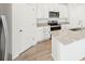 Modern kitchen with stainless steel appliances, granite countertops, and white cabinets at 31653 Wild Grape Ln, Brooksville, FL 34602