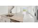 Bright kitchen island with stainless steel sink, granite countertops, and open floor plan to living room at 31653 Wild Grape Ln, Brooksville, FL 34602