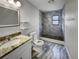 Bright bathroom featuring marble floors, white vanity, shelves and walk-in shower at 322 Hoffman Blvd, Tampa, FL 33612