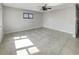Empty room with neutral walls, tile floor, a ceiling fan, and a black-framed window at 322 Hoffman Blvd, Tampa, FL 33612