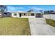 Charming single-story home featuring a covered parking area and a well-maintained front lawn at 322 Hoffman Blvd, Tampa, FL 33612