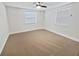 A serene bedroom with neutral carpet, two windows, and a ceiling fan at 4907 E Clifton St, Tampa, FL 33610