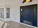 Inviting front porch with a stylish blue front door, creating a welcoming entrance at 6191 Silverdale Ave, Spring Hill, FL 34608