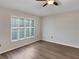 Spacious bedroom with hardwood flooring and large window allowing ample natural light at 6721 Somerset Garden Way, Apollo Beach, FL 33572