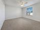 Bright bedroom features a ceiling fan, a large window, and neutral carpeting at 6804 11Th W St, Bradenton, FL 34207