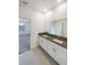 Bathroom featuring double sinks with granite counters and white cabinetry at 6856 Ripple Pond Loop, Zephyrhills, FL 33541