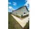 Landscaped exterior featuring a concrete sidewalk and lush green lawn at 6856 Ripple Pond Loop, Zephyrhills, FL 33541