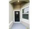 Inviting covered entry with modern black front door and sidelight window at 6856 Ripple Pond Loop, Zephyrhills, FL 33541